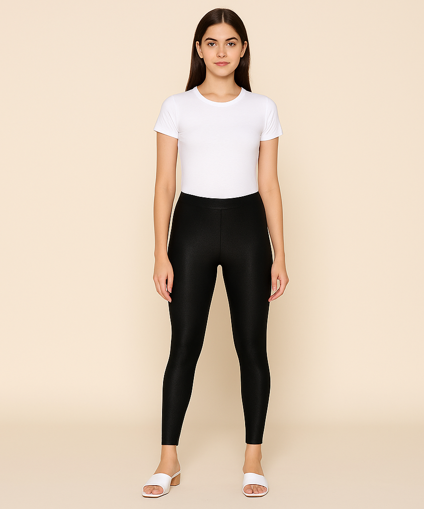 Woman wearing a white t-shirt and black leggings on a beige background