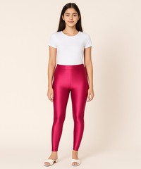Person wearing shiny pink leggings and a white t-shirt on a beige background