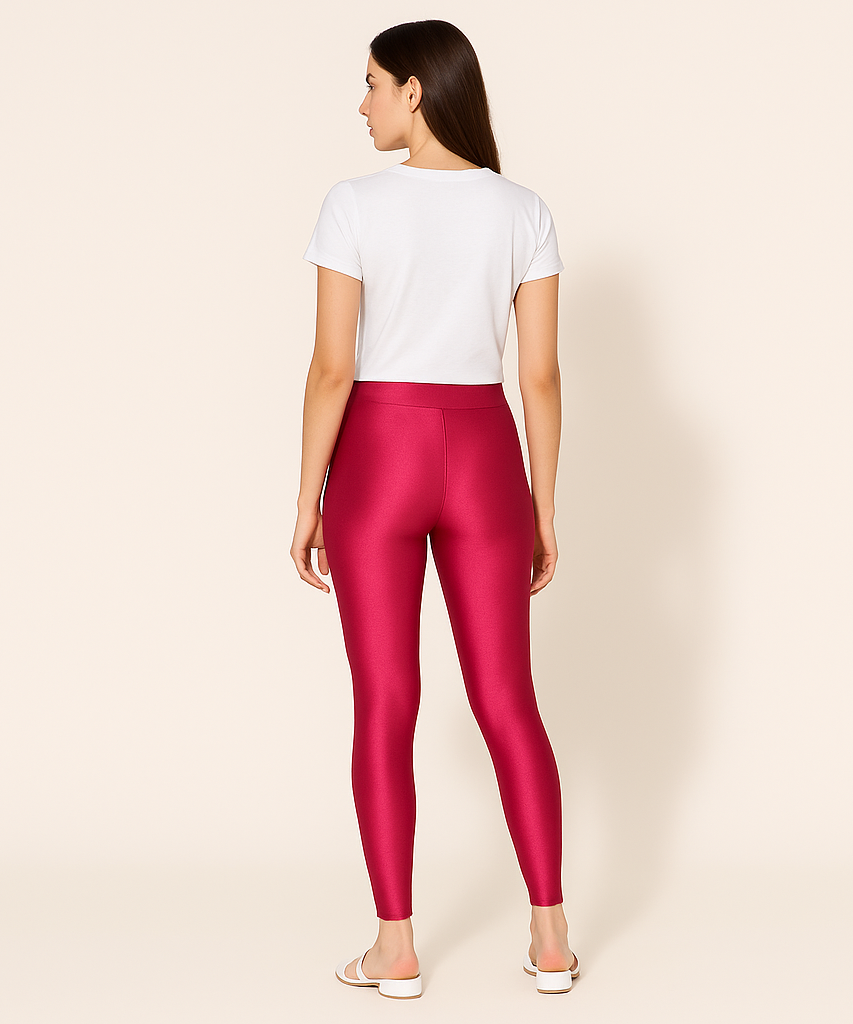 Person wearing red leggings and a white shirt on a beige background