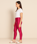 Woman wearing red leggings and a white shirt on a beige background