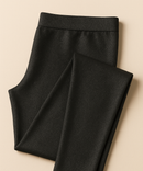 Folded black pants on a beige background