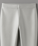 Close-up of light gray pants on a matching gray background
