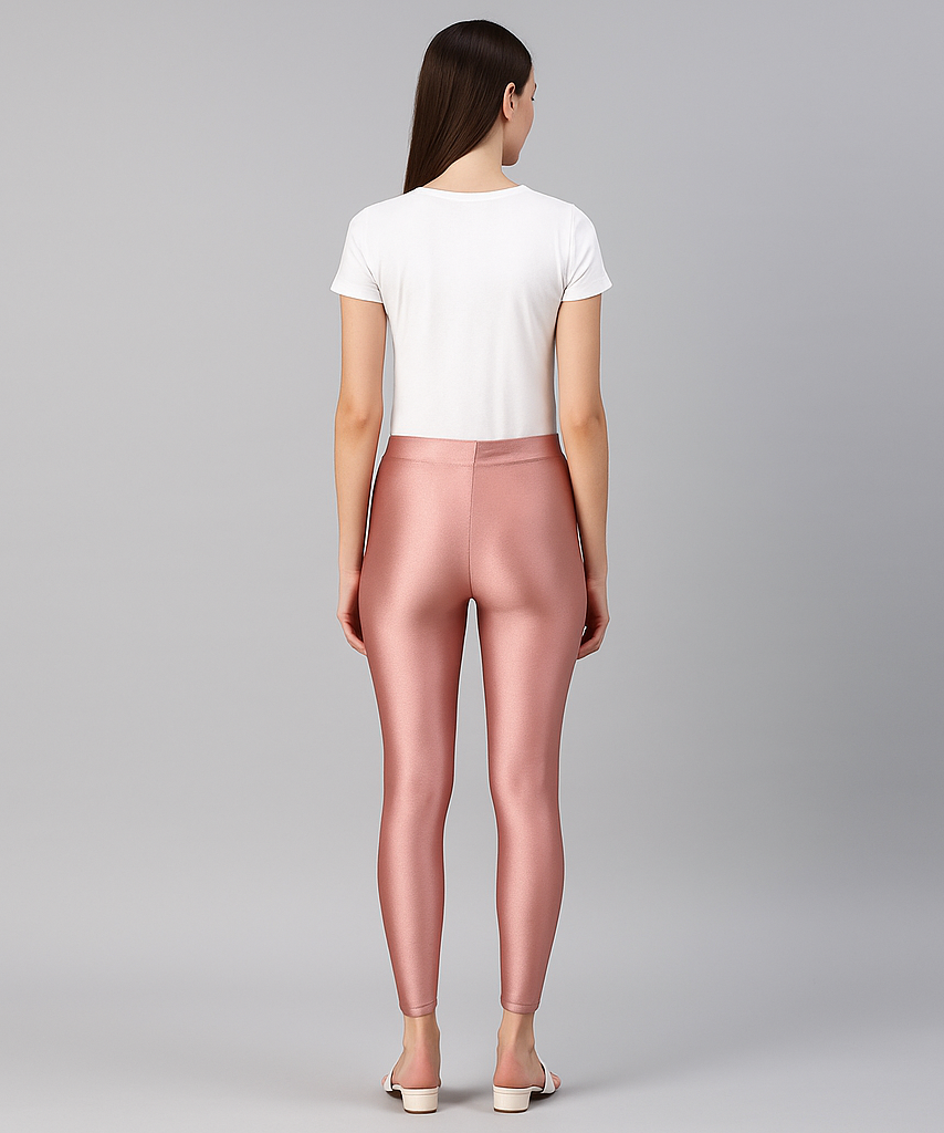 Woman wearing pink leggings and a white top on a gray background