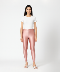Woman wearing pink leggings and a white top on a white background